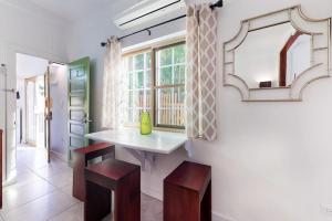a bathroom with a sink and two stools and a mirror at Rainforest Suite at Casa DV Suites -Gold Standard Certified in Caye Caulker