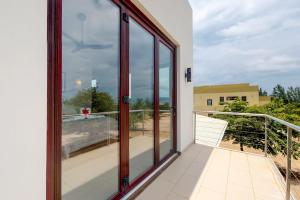 a balcony with glass doors and a view of the ocean at Green Tower House in Placencia