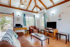 a living room with a couch and a tv at Poseidon House in Riversdale