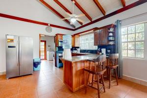 a kitchen with a refrigerator and a counter with stools at Poseidon House in Riversdale +58 photos