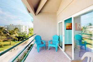 three blue chairs on a balcony with a view at Mara Laguna I301 in San Pedro +41 photos