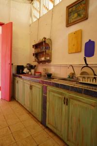 a kitchen with green cabinets and a counter top at La Casa Rosada Hostel in Jericó