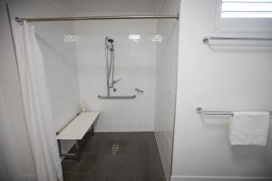 a white bathroom with a shower and a sink at Albany Central Apartments in Albany +32 photos