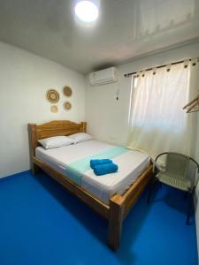 a small bedroom with a bed and a chair at Ramos de mar in Rincón