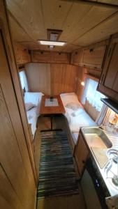 a small room with a table and a bed at Sleep inside a classic Volkswagen Westfalia or our legendary Mercedes Düdo overland cabin in central Svolvær Close to public showers and toilets NO PARKING in Svolvær +3 photos
