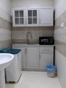 a kitchen with white cabinets and a sink at أرياف سويت in Al Baha