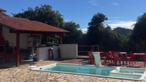a swimming pool with chairs and a gazebo at Pousada Green House Paraty in Paraty
