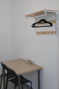 a table and chairs next to a white wall at Metropolitano Guesthouse in Madrid