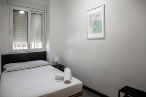 a bedroom with two beds and two windows at Metropolitano Guesthouse in Madrid
