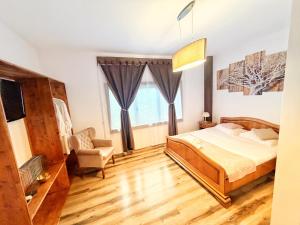 a bedroom with a bed and a chair at Wild Rose in Borşa +57 photos