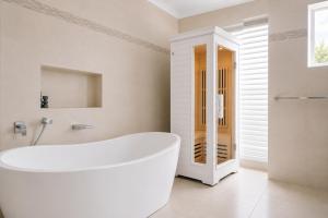 a white bath tub in a bathroom with a window at Manly Beachfront Stays - 3 Bedroom with Garden - Steps to Ferry, Beach, Shops & Restaurants in Sydney