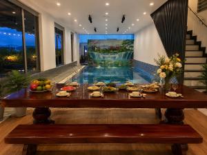 a table with plates of food on it in a house at Solwind Riverside in Danang