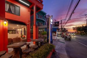a building with tables on the side of a street at Khaleej Mass Hotel Patong in Patong Beach