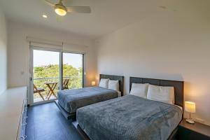 two beds in a room with a large window at Papaya 15 Apartments in Playa del Carmen +169 photos