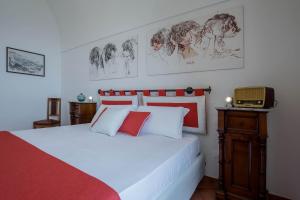 a bedroom with a white bed with drawings on the wall at Starhost - CASA BETTINA enchanting seaview in Vietri sul Mare