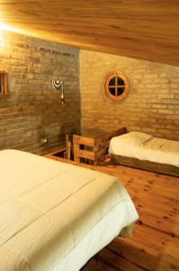 a bedroom with two beds and a brick wall at Potrerillos Nuestras Raíces in Potrerillos +58 photos