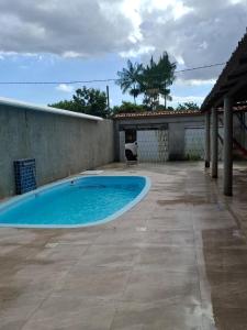 a large swimming pool in a yard with a patio at Casa de Praia in Belém +2 photos