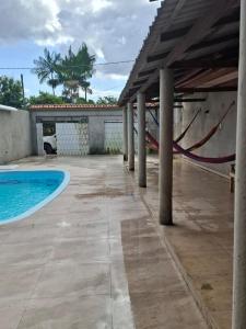 a patio with a swimming pool and a hammock at Casa de Praia in Belém