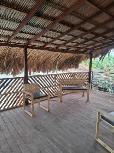 a deck with two benches and a thatched roof at Casa de Praia in Belém