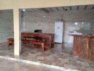 a kitchen with a table and a refrigerator in a room at Casa de Praia in Belém