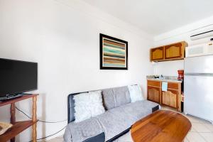 a living room with a couch and a table at Charming Suite with WiFi AC Shared Pool Grill Area & Rooftop Deck in Caye Caulker