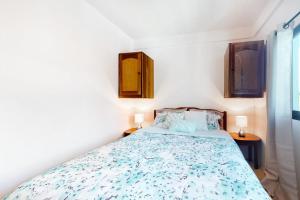 a bedroom with a bed and two lamps on two tables at Charming Suite with WiFi AC Shared Pool Grill Area & Rooftop Deck in Caye Caulker +15 photos