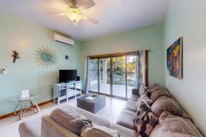 a living room with a couch and a tv at Relaxing condo with shared pool ocean views partial AC & WiFi in San Pedro