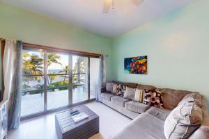 a living room with a couch and a large window at Relaxing condo with shared pool ocean views partial AC & WiFi in San Pedro