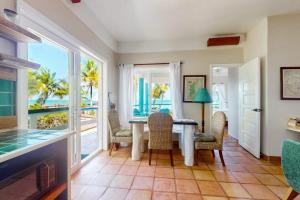 a dining room with a table and views of the ocean at Charming beachfront condo with a kitchenette shared pool WiFi & beach access in Placencia +22 photos