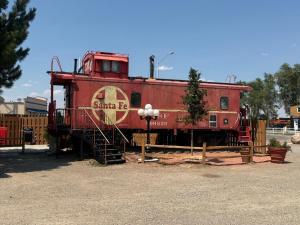 a red train sitting on display in a yard at La Junta Camping & Cabins in La Junta