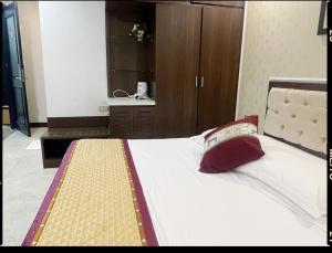a bedroom with a large bed with a red pillow at Khách sạn Rosy in Hòa Ðình +2 photos