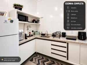 a kitchen with white cabinets and a white refrigerator at Casa Lago da Dinda 3 in Espirito Santo Do Pinhal