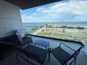 a balcony with chairs and a view of the ocean at Ștefan Seafront Residence in Năvodari