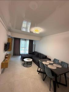a living room with a black couch and tables at Ștefan Seafront Residence in Năvodari