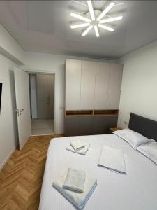 a bedroom with a white bed with two towels on it at Ștefan Seafront Residence in Năvodari