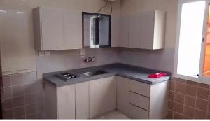 a kitchen with a sink and white cabinets at شقة غرفتين وصالة 5 in Al Baha