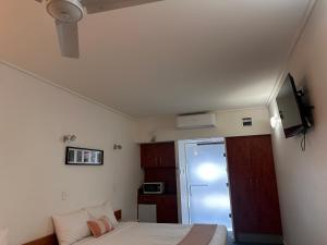 a small bedroom with a bed and a tv at Ayr Traveller's Motel in Ayr