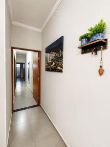 a hallway with a white wall with a picture on it at Casa Lago da Dinda 3 in Espirito Santo Do Pinhal