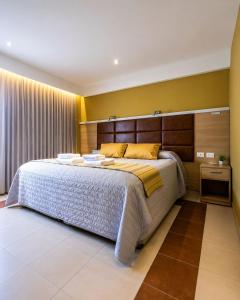 a bedroom with a large bed with a wooden headboard at Hotel Leonardo Da Vinci in Añelo
