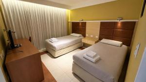 a hotel room with two beds and a desk at Hotel Leonardo Da Vinci in Añelo