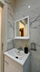 a bathroom with a white sink and a mirror at Plage & Confort in Fnidek