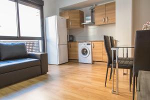 a kitchen and living room with a refrigerator and a table at Apartamento Eursu centro con piscina in Málaga