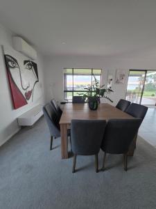 a dining room with a wooden table and chairs at Tiatukia Beach House in North Shields