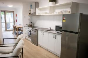 a kitchen with white cabinets and a stainless steel refrigerator at Albany Central Apartments in Albany