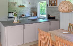 a kitchen with white cabinets and a wooden table at Cozy Home In Jerup With Wifi in Jerup