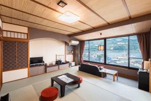 a living room with a couch and a tv at Inatori Akao Hotel in Higashiizu