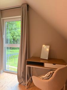 a desk with a laptop on it next to a window at Leśna Sonata in Marksoby