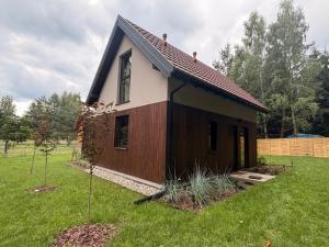 a small house in a yard with two trees at Leśna Sonata in Marksoby