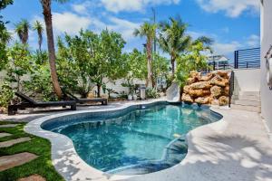 a swimming pool in a yard with palm trees at Knot A Basic Beach House in Bailey Hall