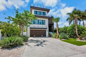 a home with palm trees and a driveway at Knot A Basic Beach House in Bailey Hall